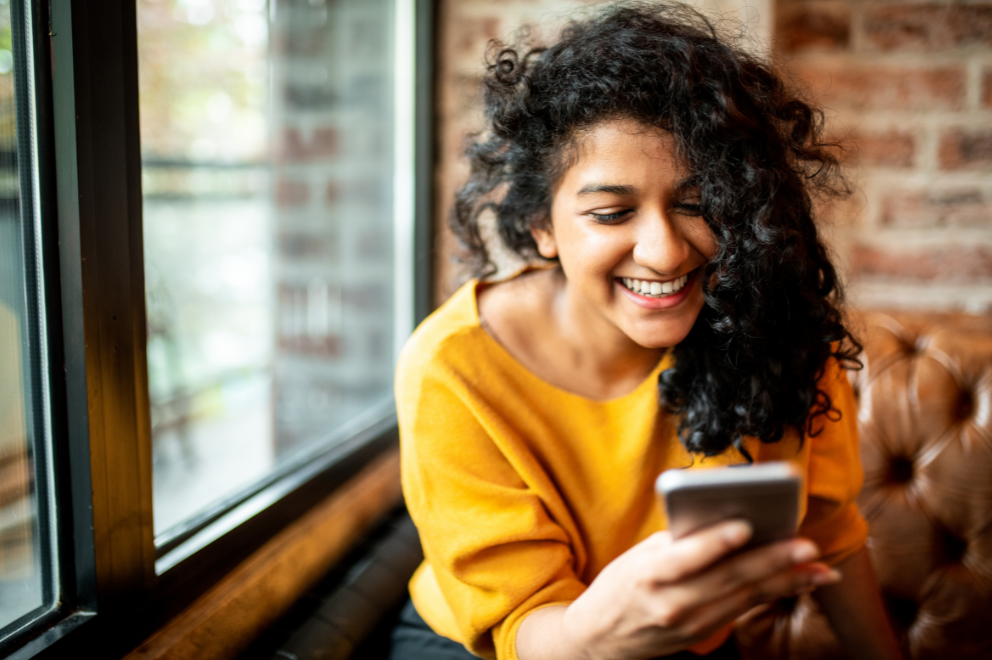 Woman holding cell phone and smiling